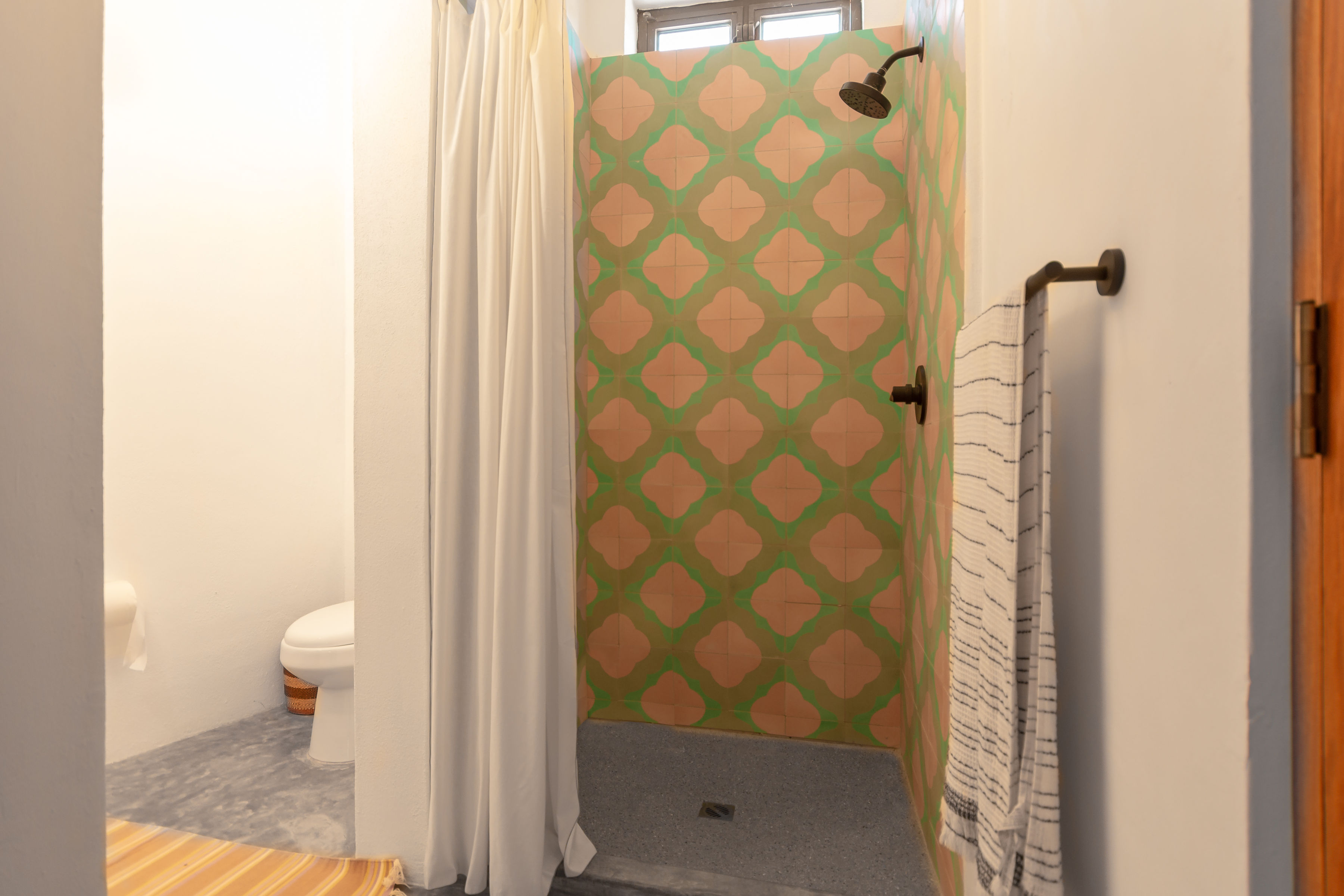 The same casita bathroom seen from the doorway: tiled walk-in shower with a curtain, and the toilet beside it