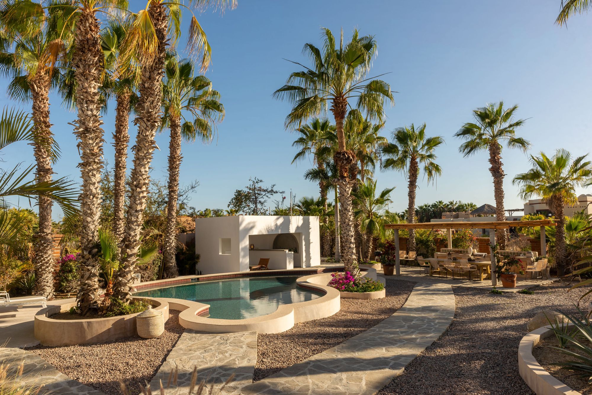 The curved saltwater pool, cabana and dining pergola across the Casa del Arte compound