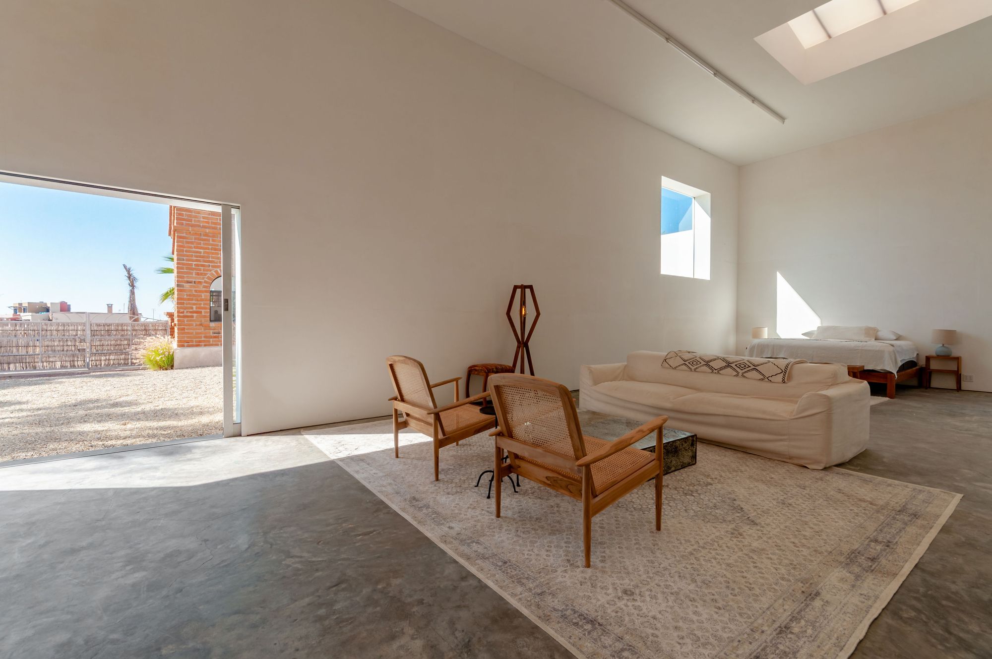 The modernist studio building, skylit white walls open to the brick courtyard beyond